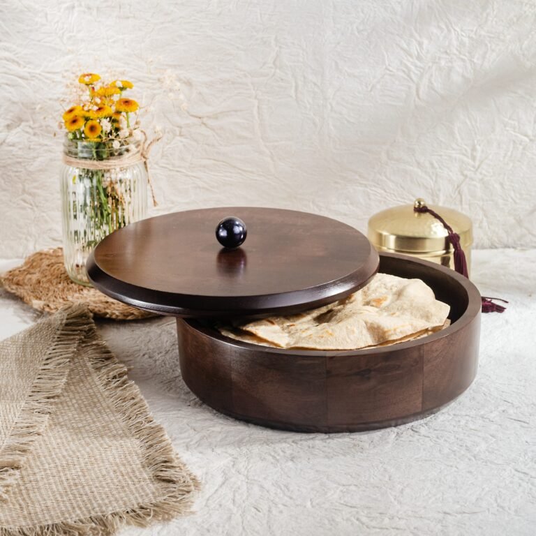 "- Premium Mango Wood – Handcrafted from seasoned mango wood with a polished finish, offering durability and a rich natural grain - Natural Heat Retention – Dense wood construction keeps rotis, chapatis, and tortillas warm and fresh for longer - Secure Wooden Lid with Knob – Ergonomic lid ensures freshness while providing an easy grip for serving - Multi-Purpose Storage – Ideal for rotis, parathas, tortillas, bread, or as a serving bowl for snacks and dry foods
