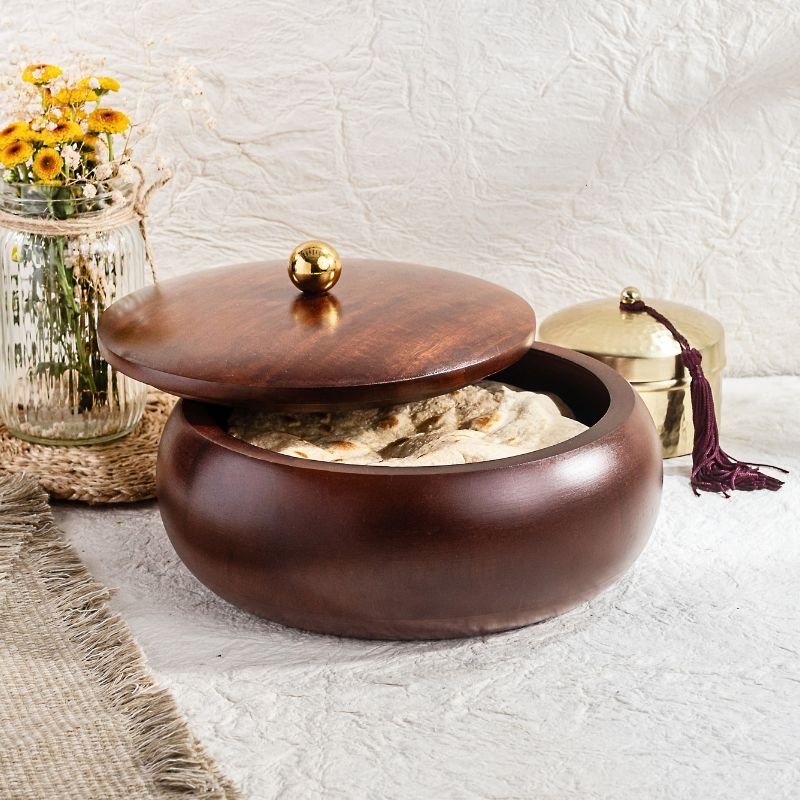 Lividora® Handcrafted Wooden Oval Chapati Box "- Premium Mango Wood – Handcrafted from seasoned mango wood with a polished finish, offering durability and a rich natural grain - Natural Heat Retention – Dense wood construction keeps rotis, chapatis, and tortillas warm and fresh for longer - Secure Wooden Lid with Knob – Ergonomic lid ensures freshness while providing an easy grip for serving - Multi-Purpose Storage – Ideal for rotis, parathas, tortillas, bread, or as a serving bowl for snacks and dry foods
